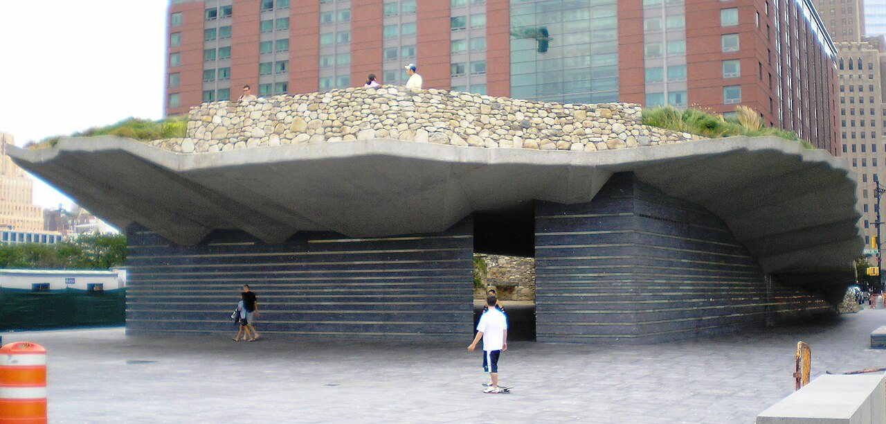 The Irish Hunger Memorial seen from the street: the raised stone field above its slate base, the inscribed passage running underneath